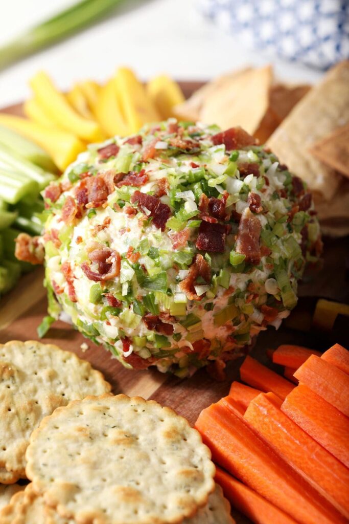 Close up of a cheeseball coated in green onions and crisp bacon