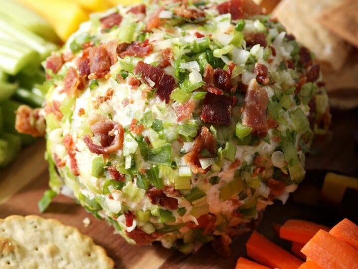 Close up of a cheeseball coated in green onions and crisp bacon