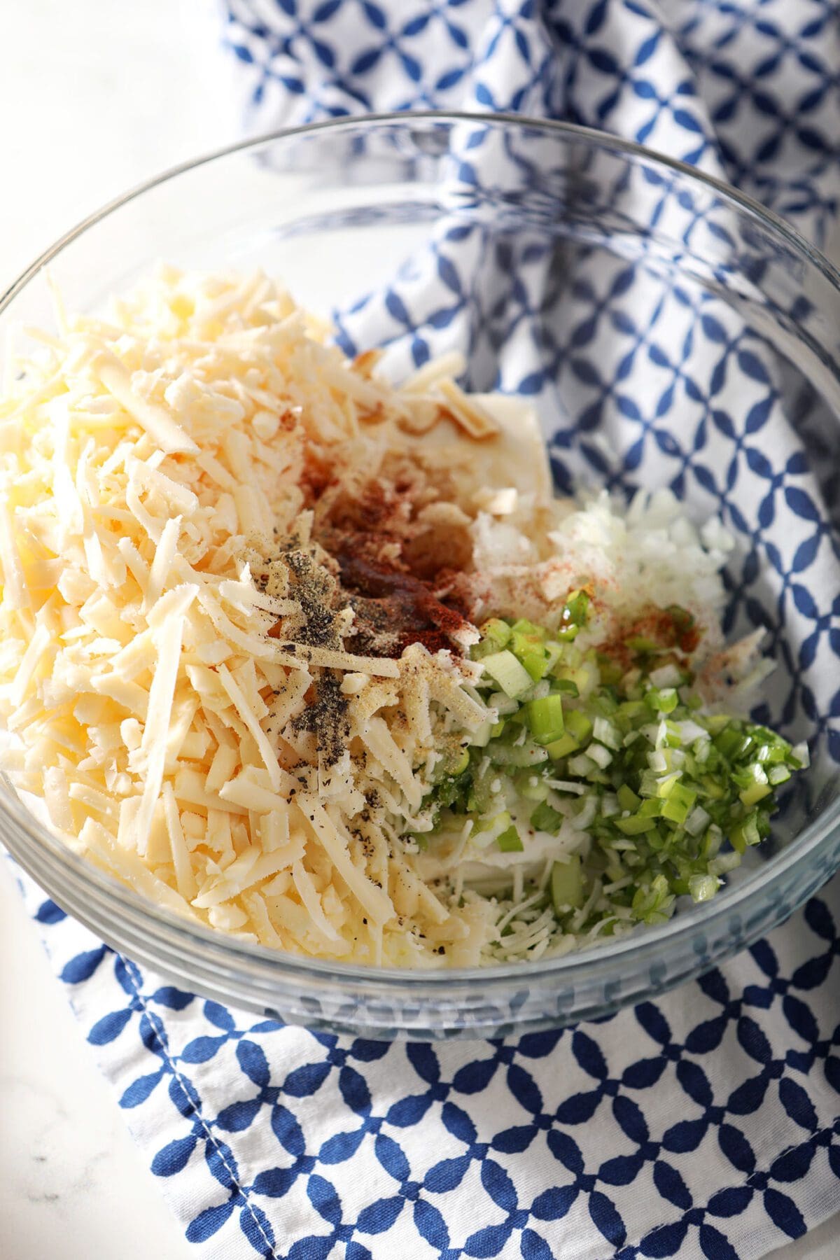 Cheeses and other ingredients in a large bowl before mixing