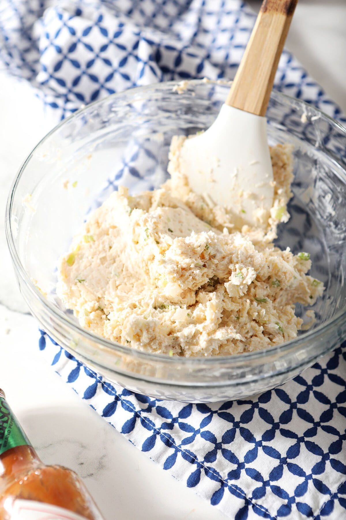 Cheeseball mixture coming together in a large bowl with a rubber spatula