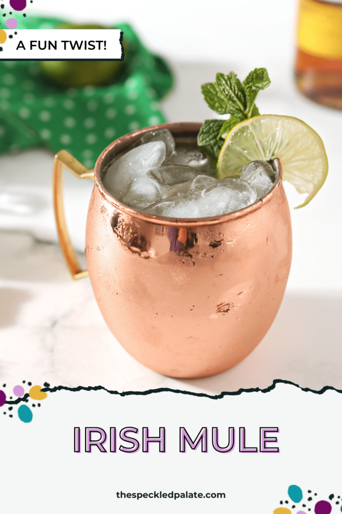 A copper mug holds an Irish Mule on a marble background, surrounded by ingredients with the text Irish Mule