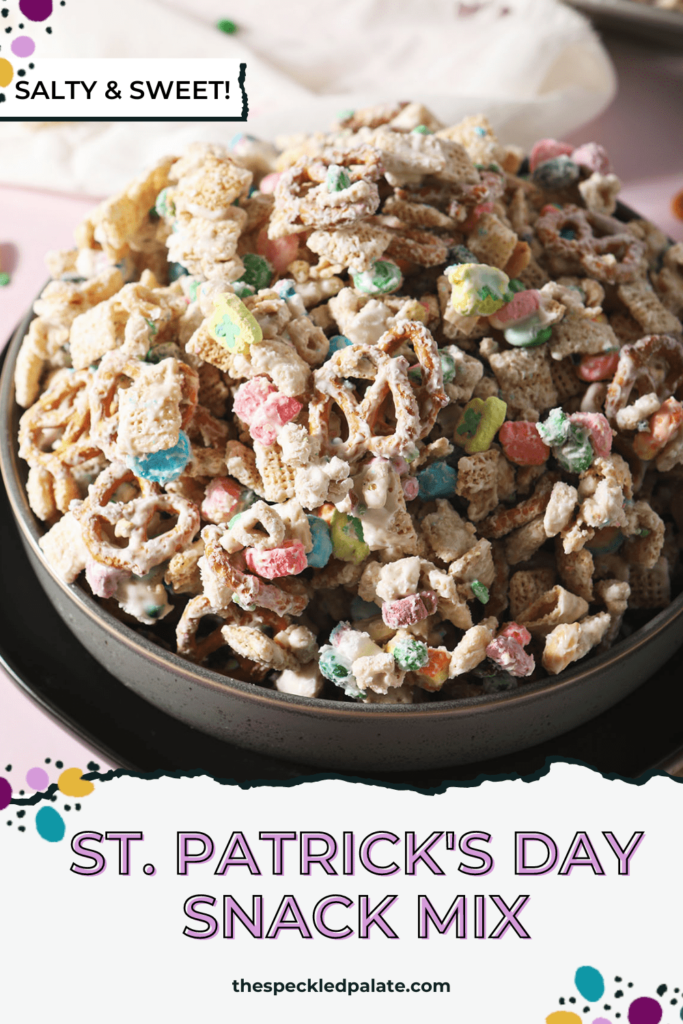 Close up of a black bowl holding a sweet chex mix recipe with candies and marshmallows with the text St. Patrick's Day Snack Mix