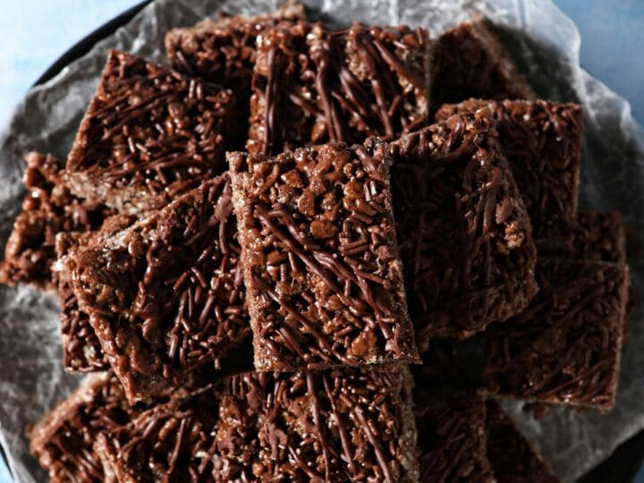 A platter of homemade Chocolate Rice Krispies on a blue surface