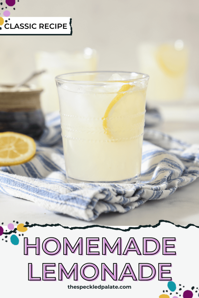 A glass of fresh squeezed lemonade garnished with a lemon round on a blue and white towel with the text homemade lemonade