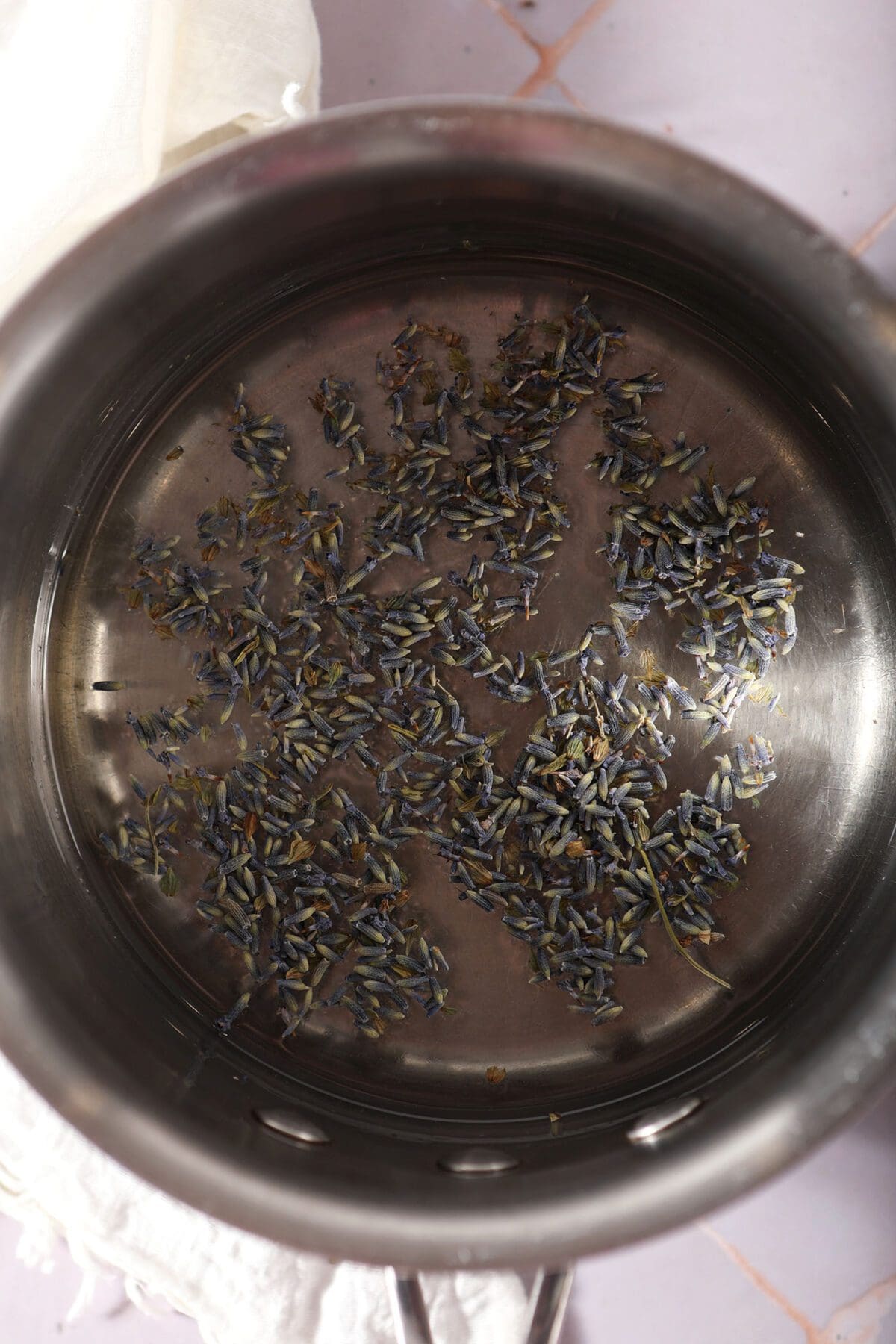 Lavender simple syrup infuses in a saucepan