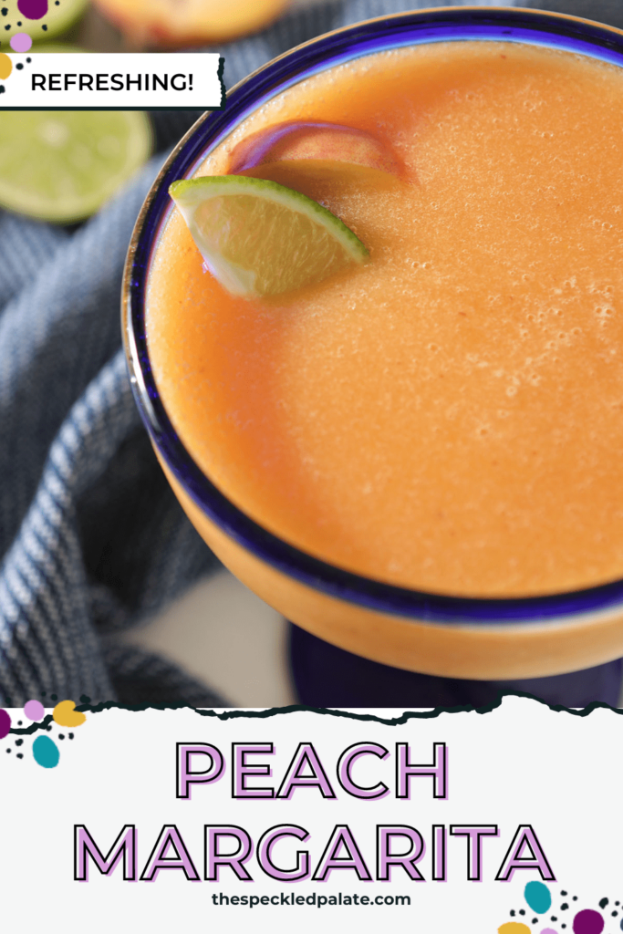 Close up of a blue-rimmed margarita glass holding an peach margarita with the text peach margarita