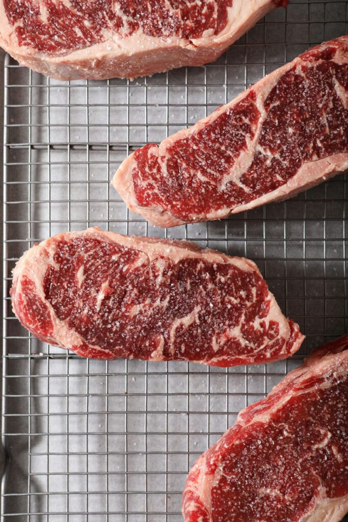 Raw steaks on a wire cooling rack