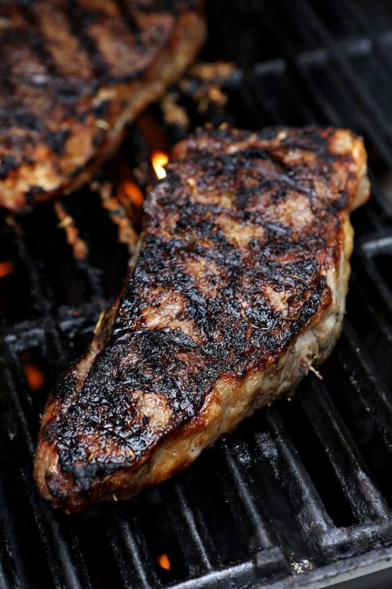 Two steaks on a grill after flipping