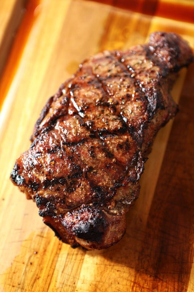 A grilled steak on a cutting board before slicing