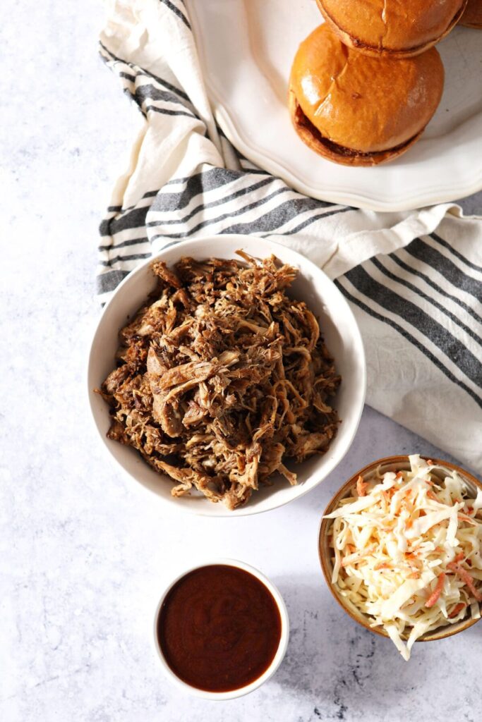 Bowls of pulled pork, slaw and bbq sauce to make pulled pork sandwiches