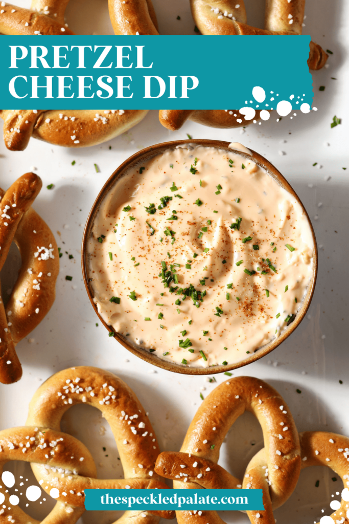 A bowl of cheese dip garnished with paprika and chives and surrounded by soft pretzels with the text pretzel cheese dip