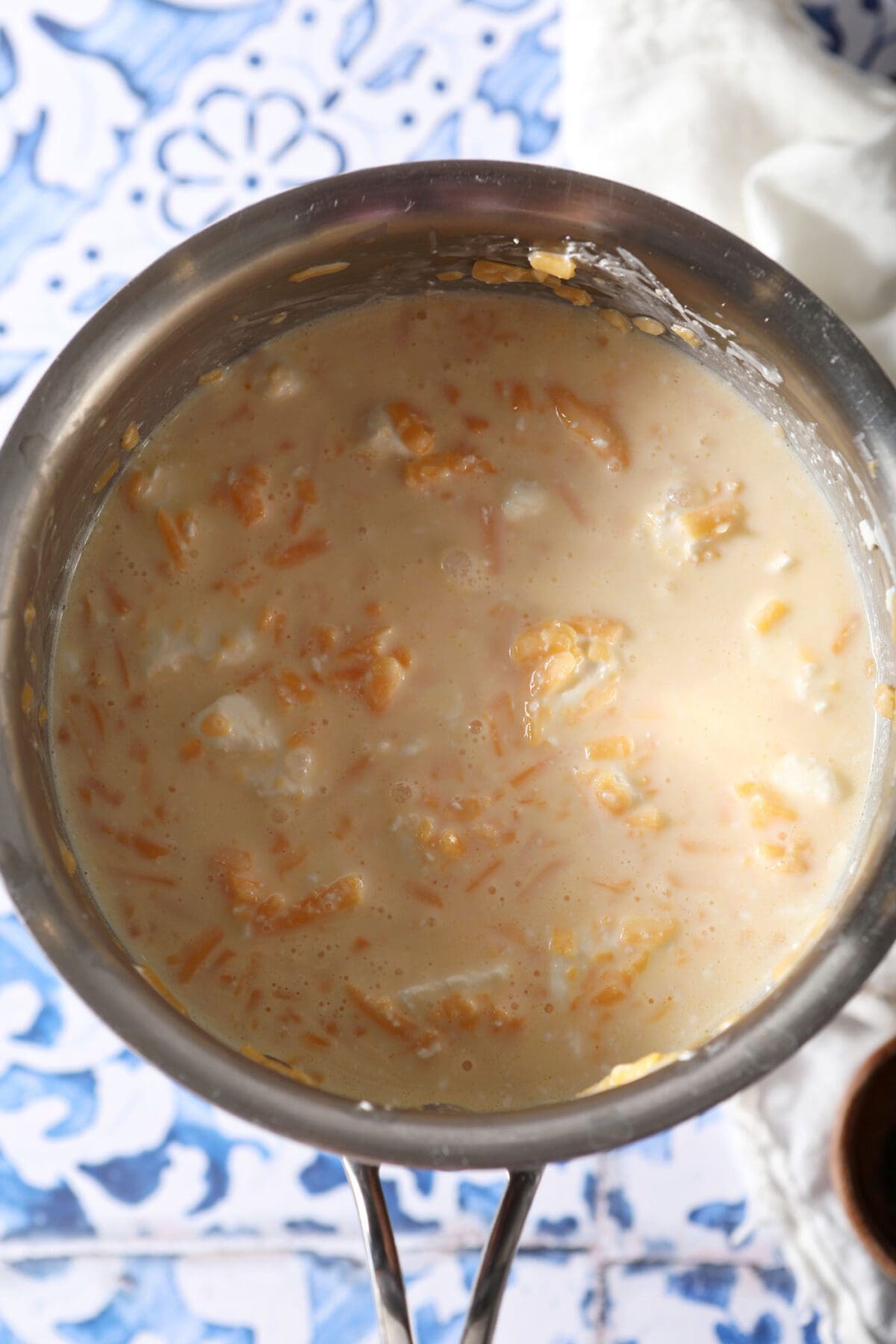 Melting cheeses with milk in a saucepan