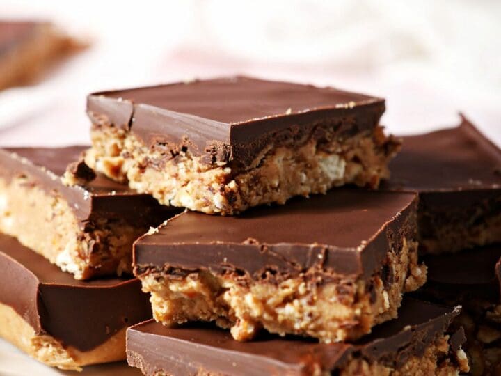 A scalloped plate holds a stack of Chocolate Peanut Butter Bars