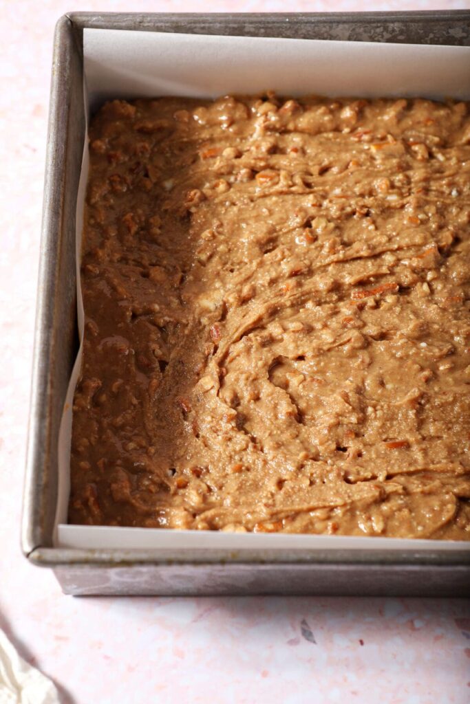 The base for peanut butter bars in a square metal pan