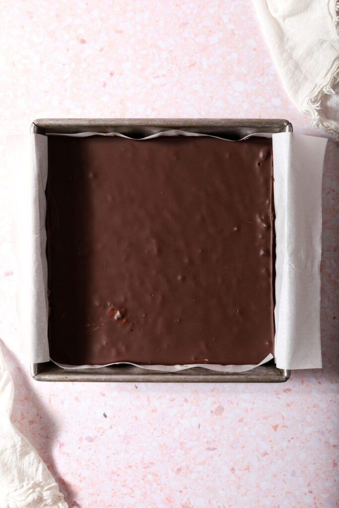 Chilled peanut butter bars topped with chocolate before slicing