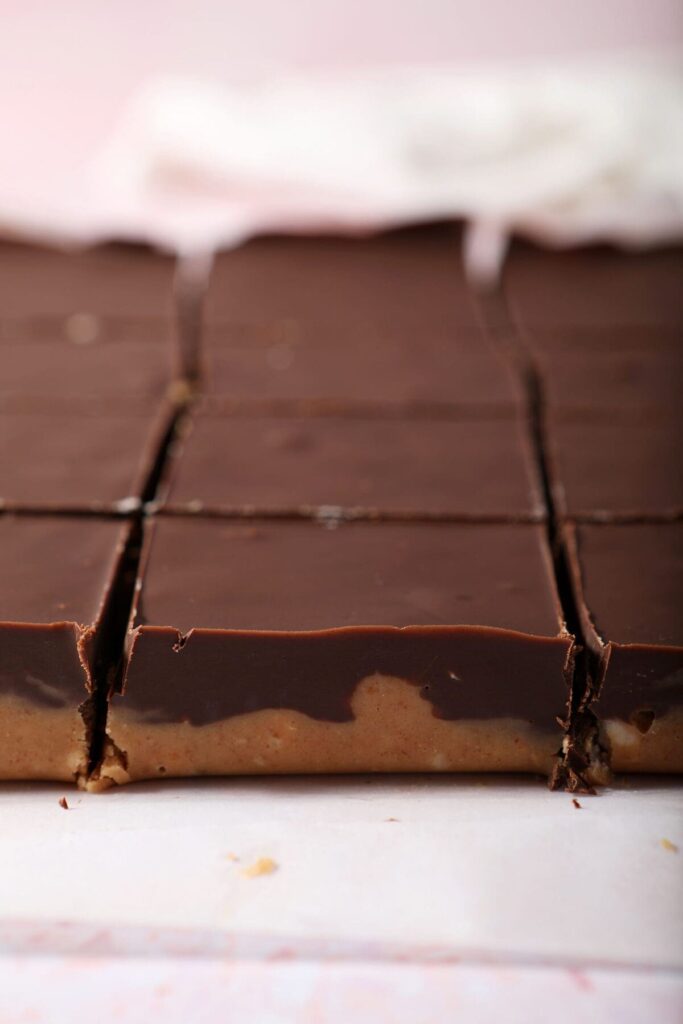 Sliced Chocolate Peanut Butter Bars on parchment before they are placed on a plate