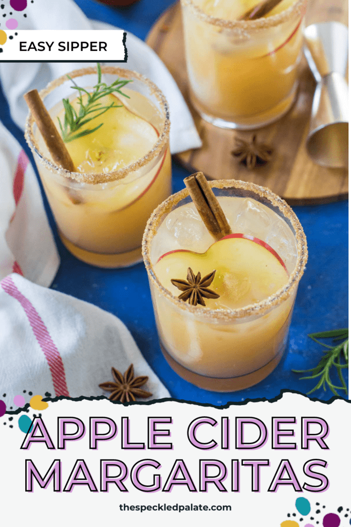 Three fall margaritas garnished with apple, cinnamon and star anise sit on a blue background with the text ' apple cider margaritas'