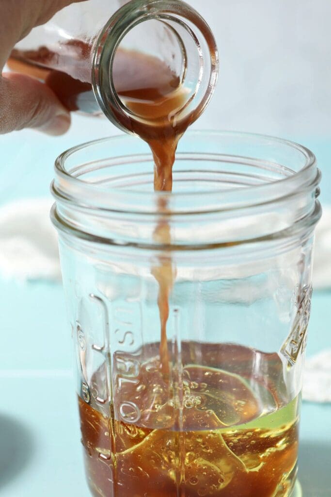 Red liquid is poured inside a mason jar