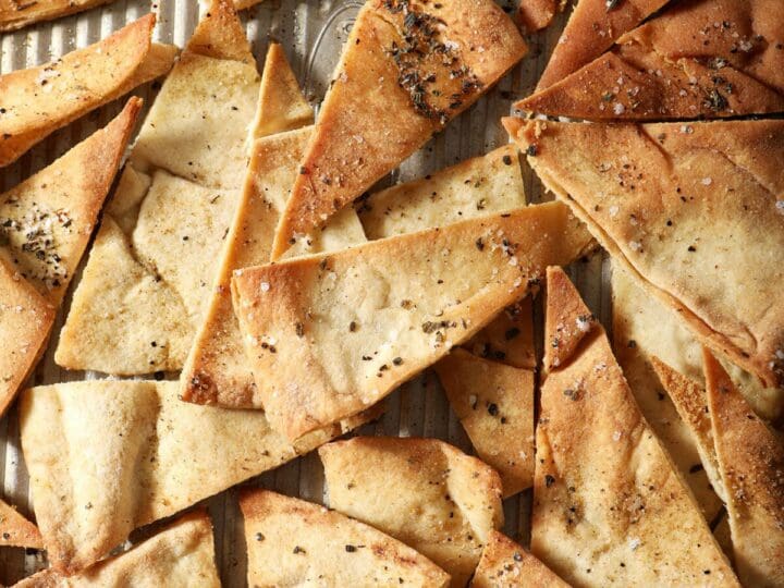 Close up of golden brown baked pita chips on a sheet pan