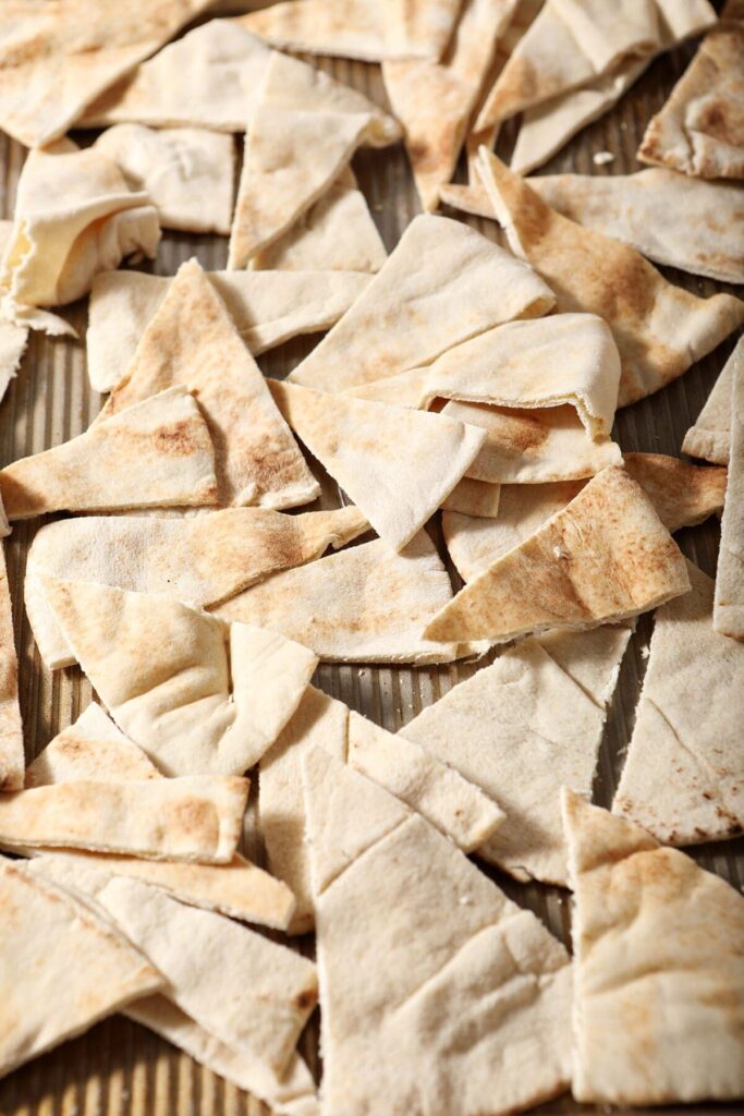 Pita triangles on a sheet pan before seasoning and baking