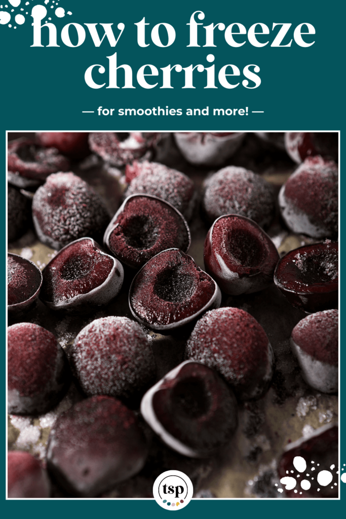 Close up of frozen halved cherries on a sheet pan with the text how to freeze cherries for smoothies and more!