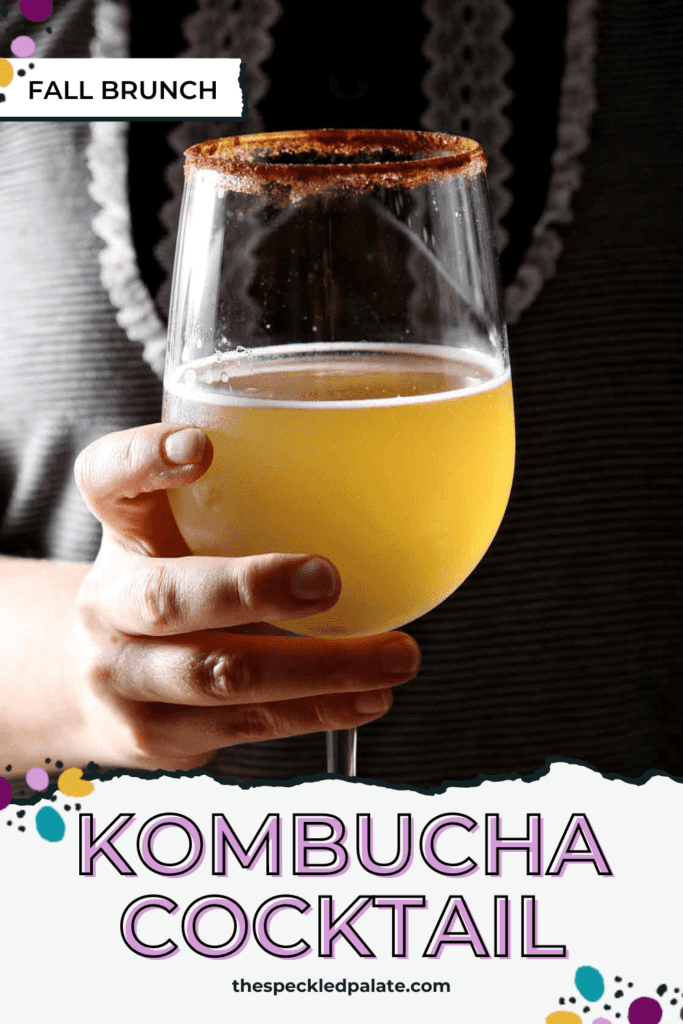 A woman wearing a black and white shirt holds a kombucha cocktail in a wine glass with the text kombucha cocktail