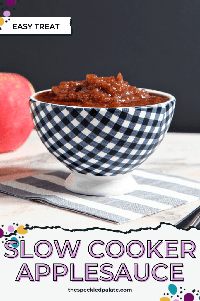 A bowl of cinnamon applesauce in front of 2 red apples with the text slow cooker applesauce