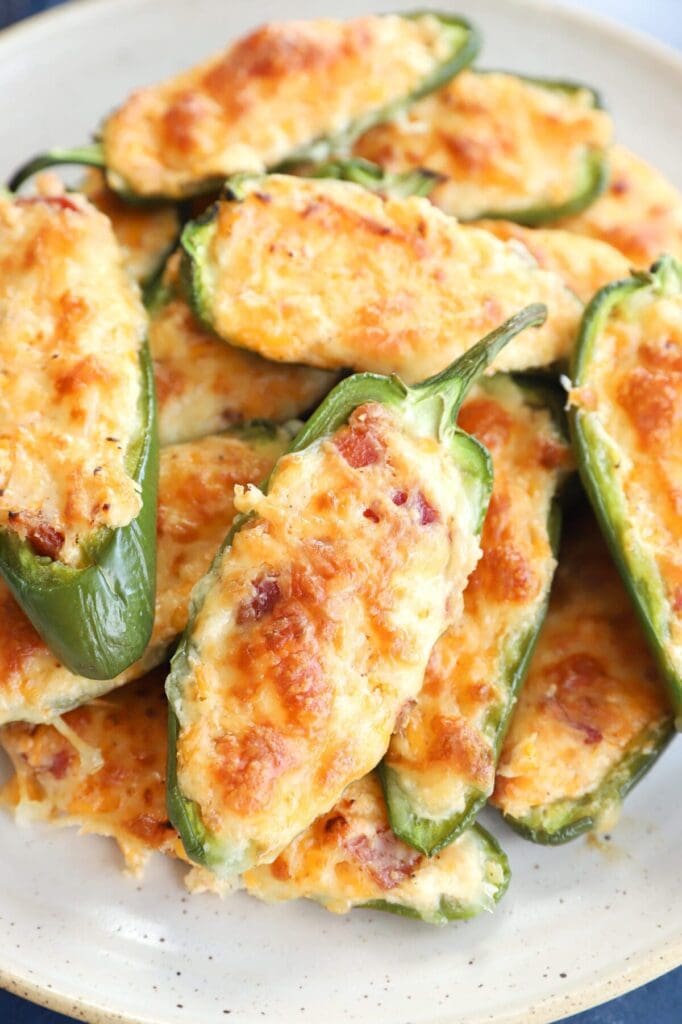 A white platter of baked jalapeño poppers