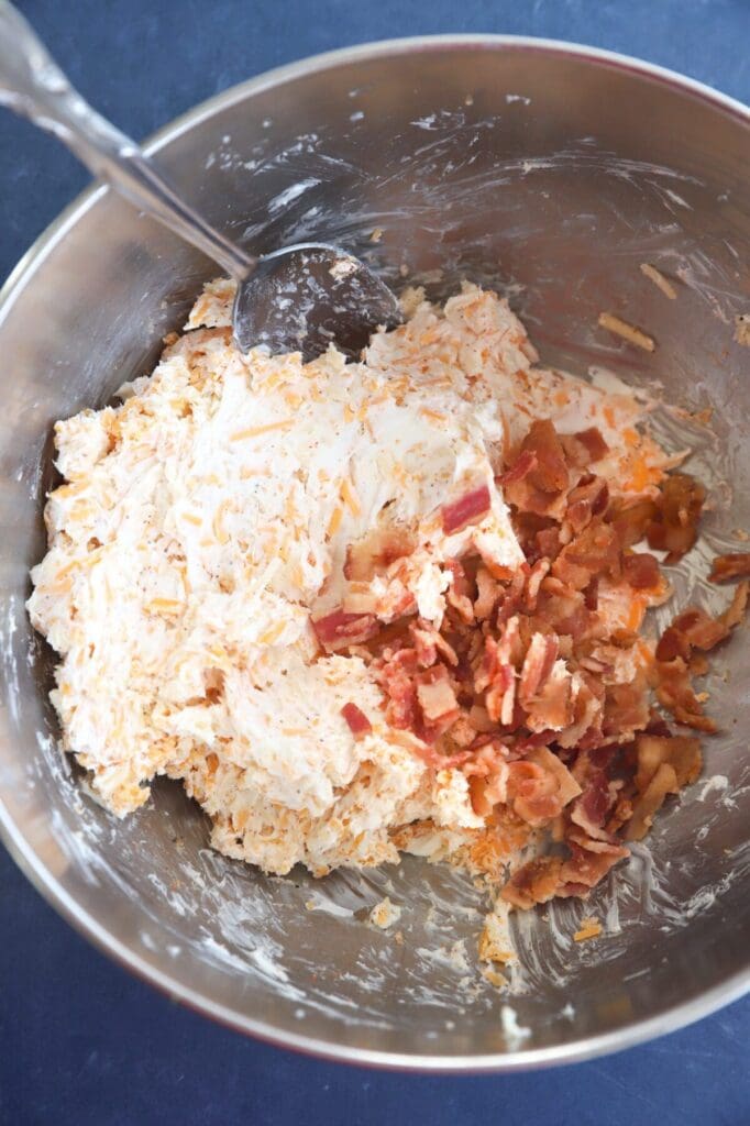 Bacon is added to the cream cheese mixture in a mixing bowl