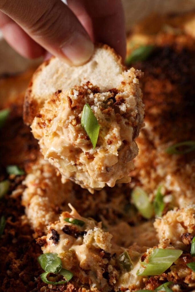 A baguette scoops up crawfish dip