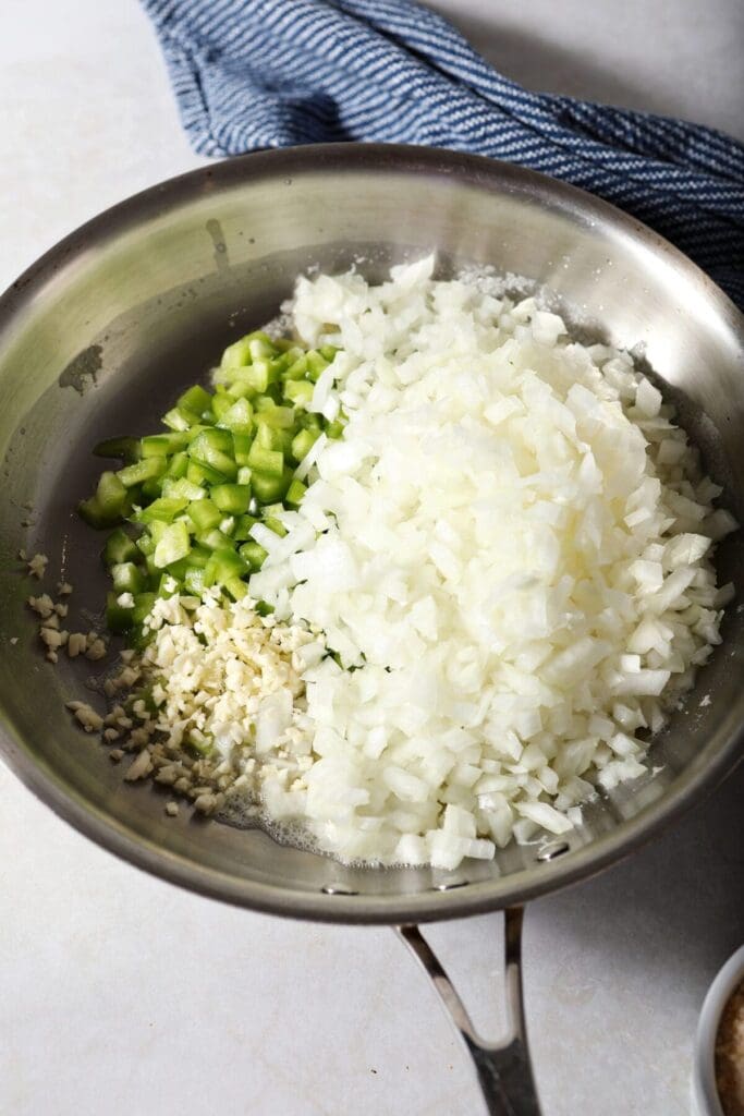 Onions, garlic and green bell pepper in a pan