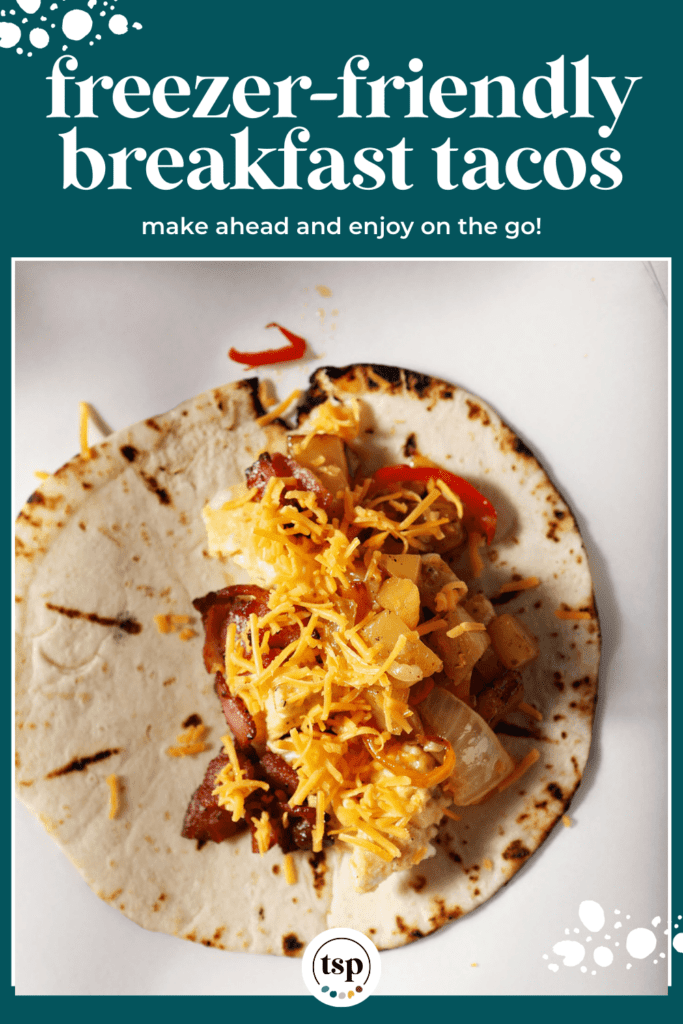 Shredded cheese on top of a breakfast taco on parchment paper with the text freezer-friendly breakfast tacos make ahead and enjoy on the go