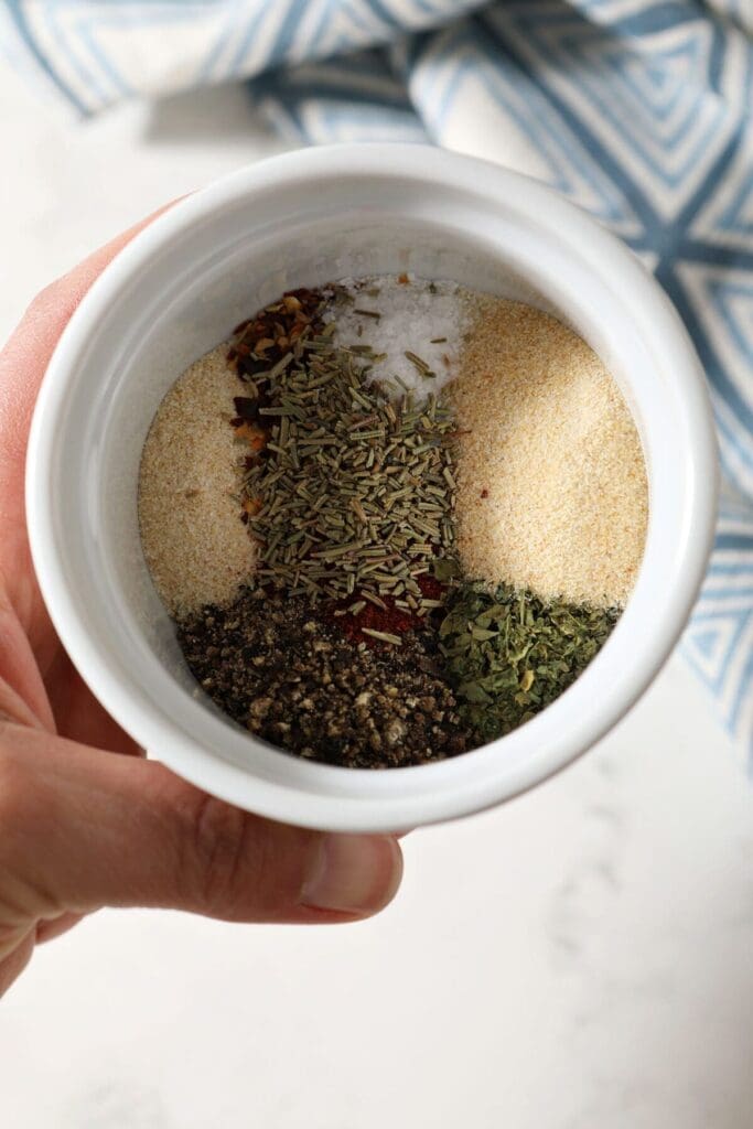 Ingredients to make a steak seasoning blend in a white bowl before mixing