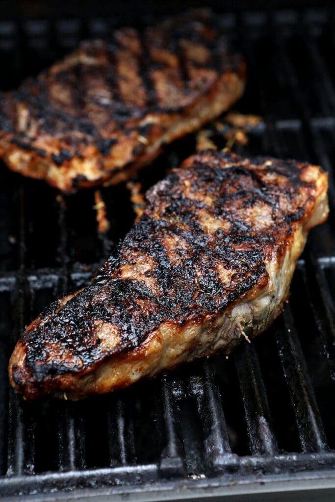 Two steaks on a grill with char marks