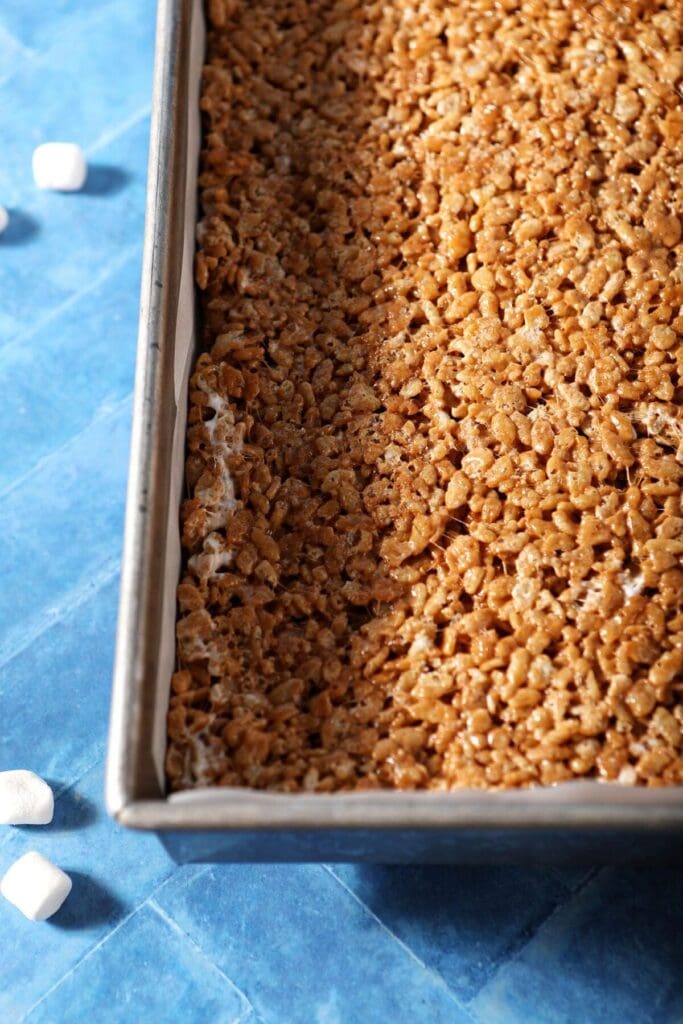 A tray of Pumpkin Spice Rice Krispie Treats on a blue tiled surface