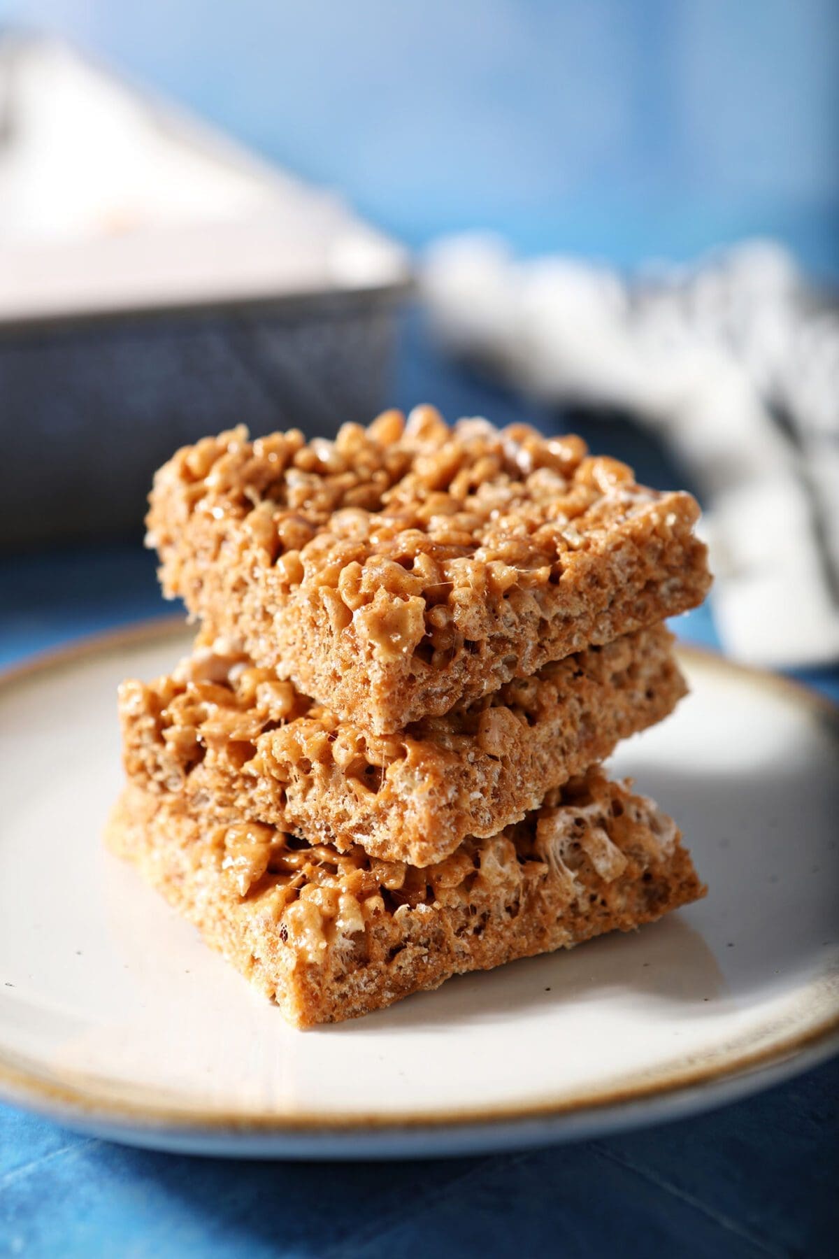 A stack of three Pumpkin Spice Rice Krispie Treats on a white plate