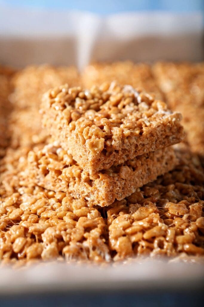 Two Rice Krispie treats stacked on top of each other on top of a pan of others