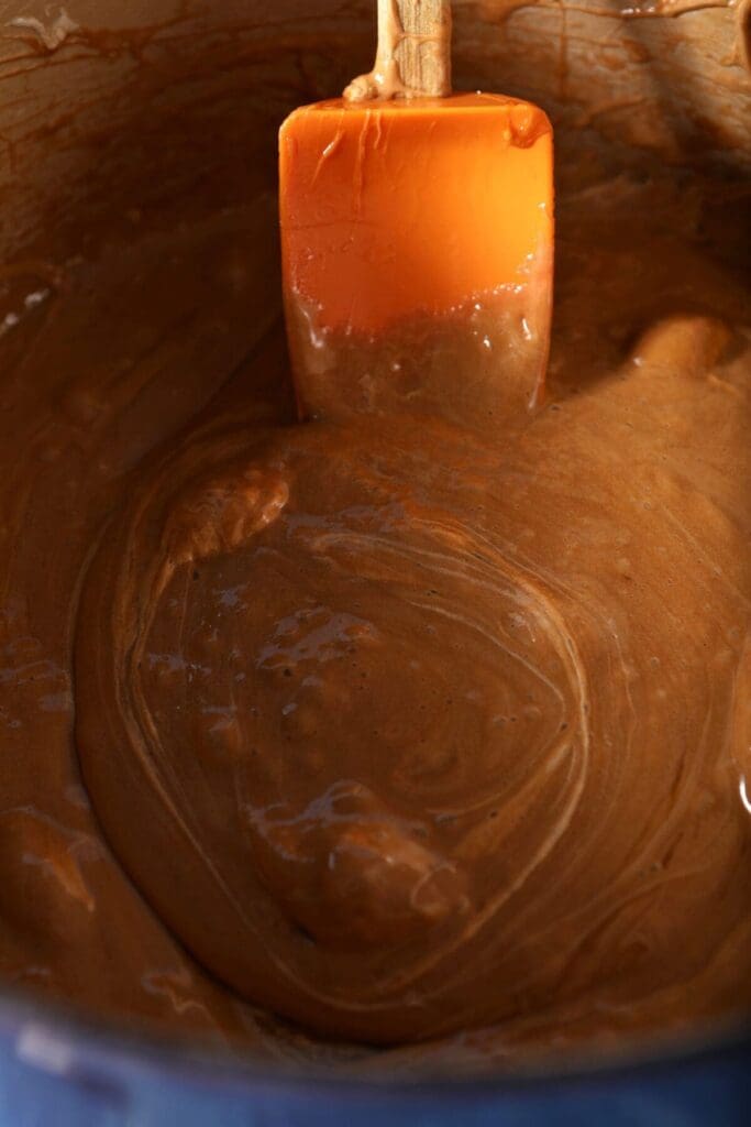 Melted marshmallows in a pan with a orange spatula