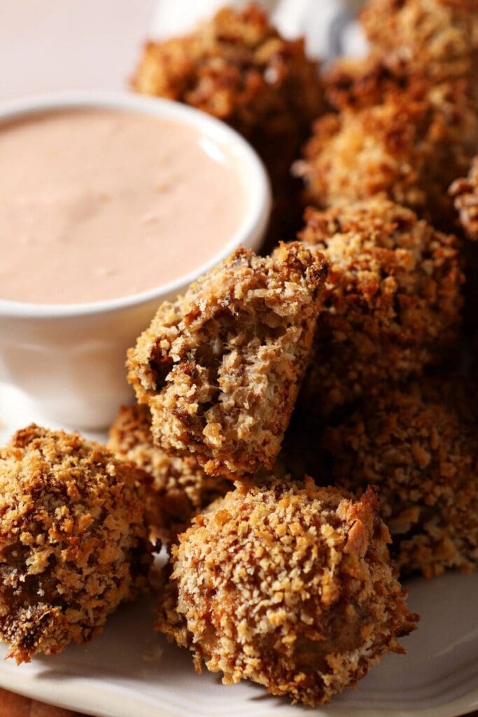 Boudin balls on a plate next to a dipping sauce