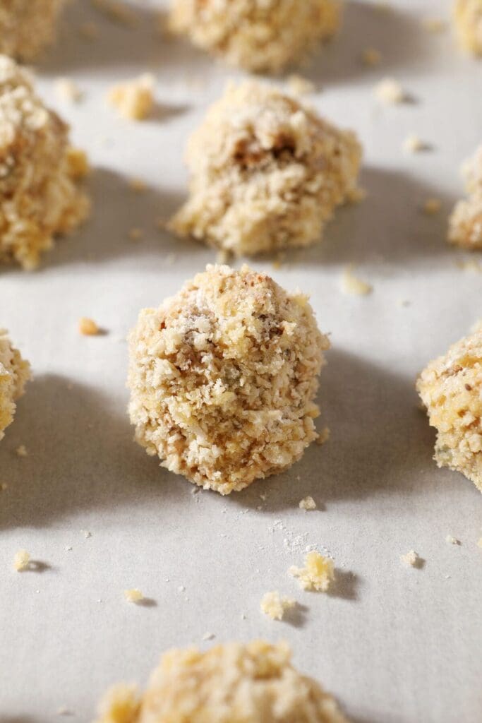 Boudin balls breaded in panko on a sheet pan before baking