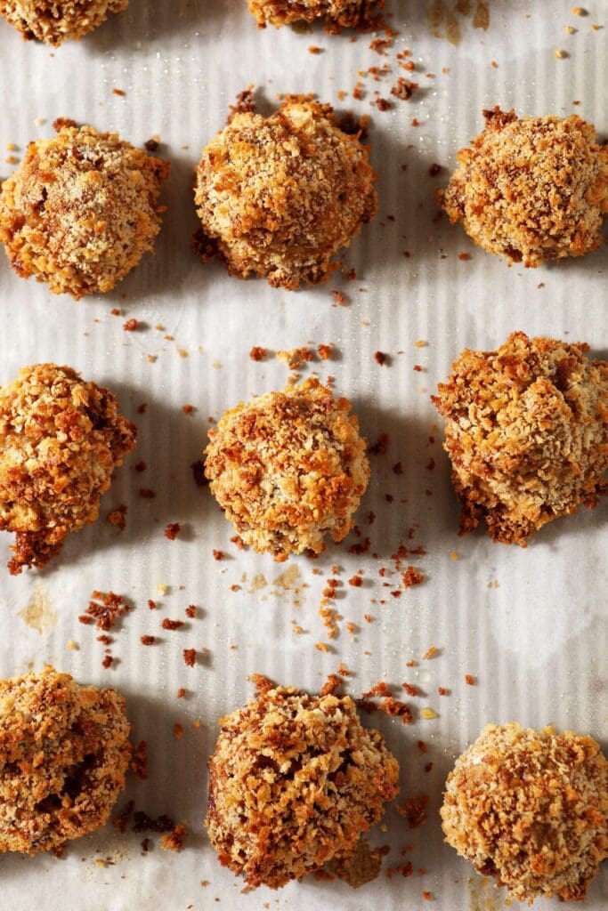 Golden brown boudin balls on a sheet pan after baking