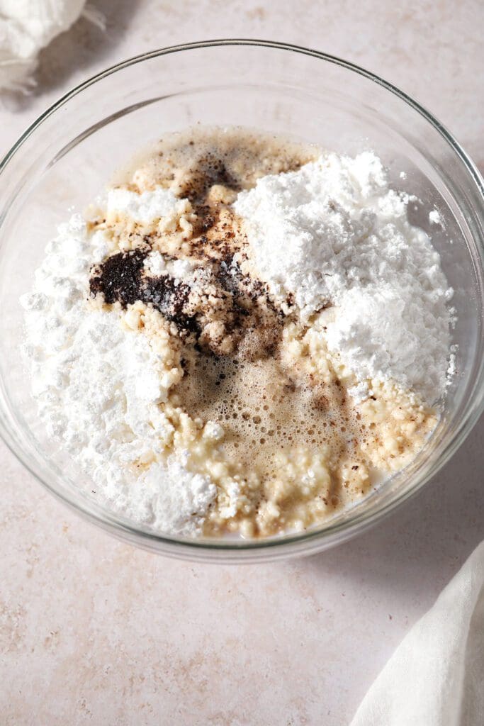 Ingredients to make brown butter frosting in a bowl, before mixing