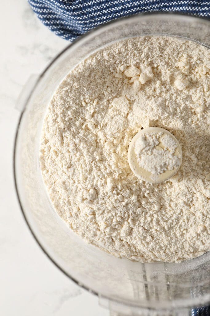 Pie crust ingredients in a food processor before liquid ingredients are added