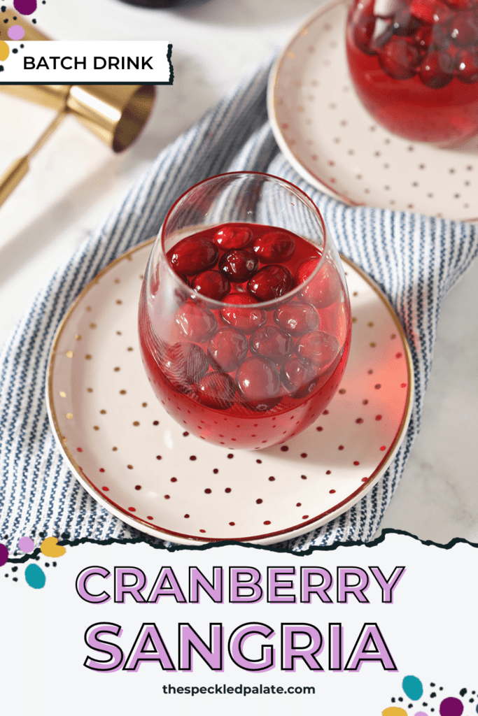 Two glasses of Cranberry Sangria sit on golden plates, ready for sipping with the text Cranberry Sangria