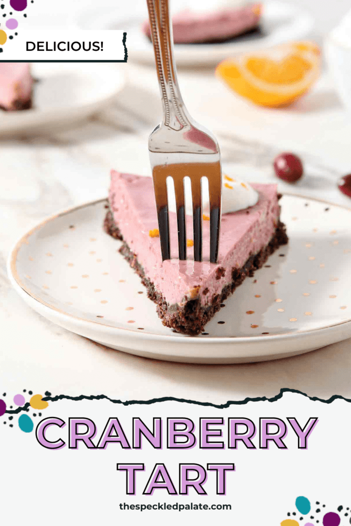 a fork cuts into a slice of a pink tart on a white and gold dotted plate with the text cranberry tart