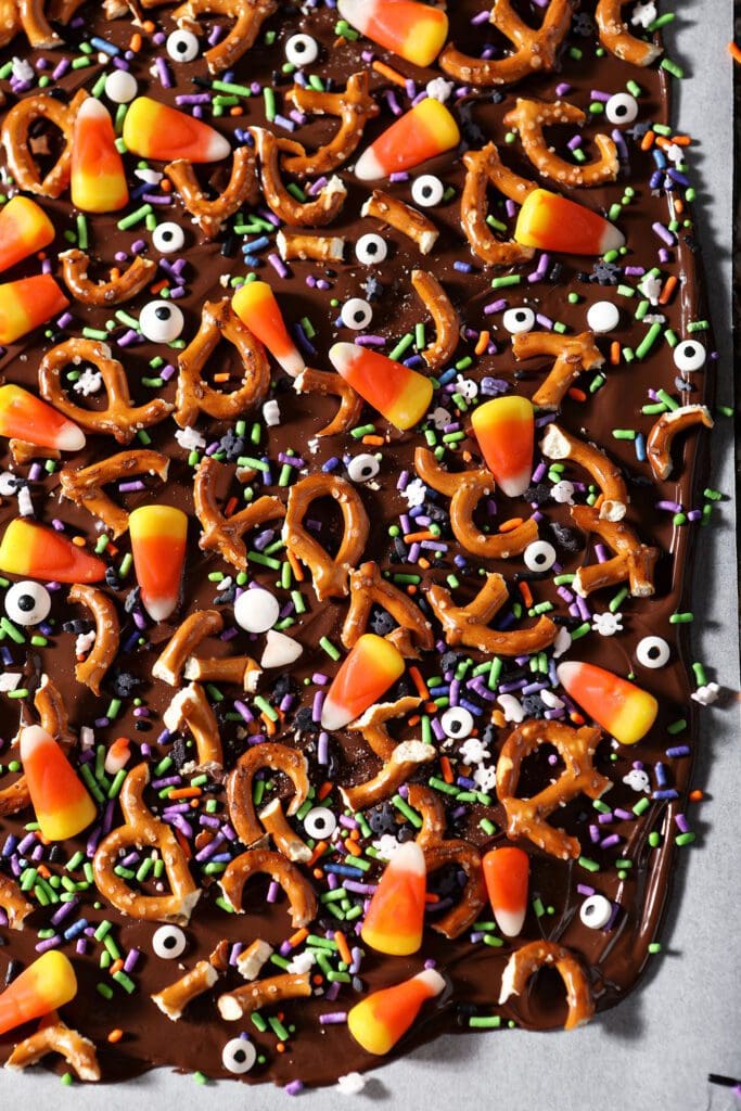 halloween bark on parchment on a sheet pan before slicing