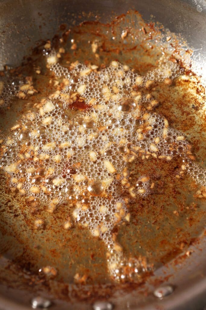 Cooked garlic in a skillet with bacon grease