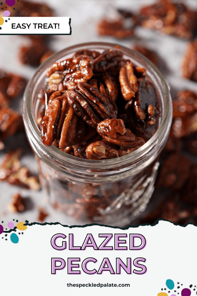 A glass jar of glazed pecans on top of a sheet pan with more pecans with the text glazed pecans