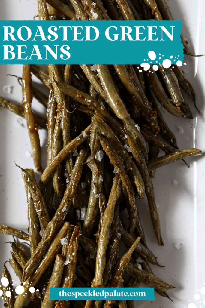 close up of green beans on a white platter with the text roasted green beans