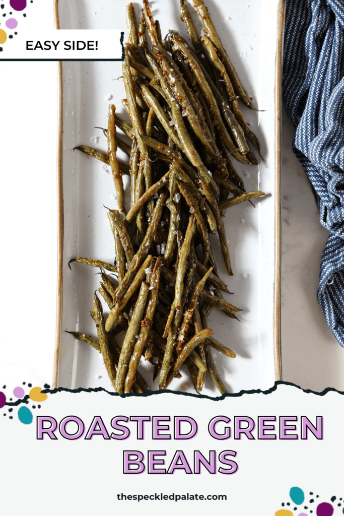 Roasted green beans on a white platter next to a blue linen on marble with the text roasted green beans